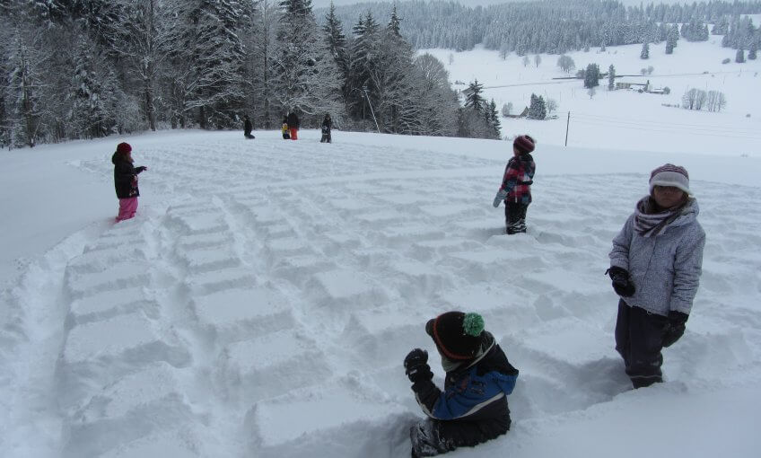 Les enfants font des carrés dans la neige.