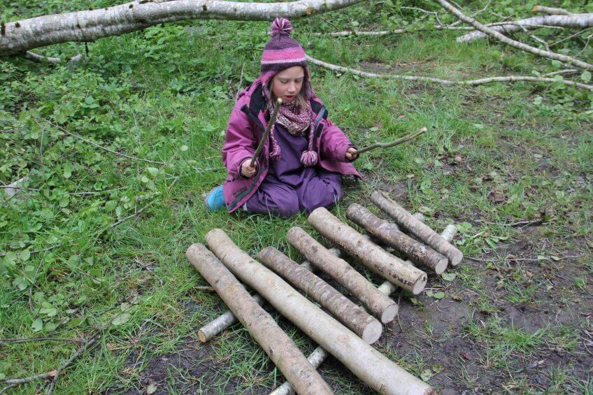 Une enfant avec un xylophone naturel.