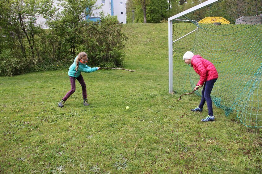 Des enfants jouent au jeu de la crosse.